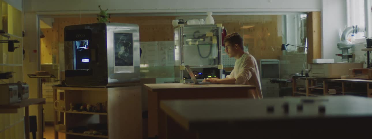 A man is sitting at a table working on a laptop computer