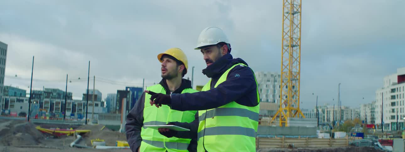 Two construction workers talk at the construction site