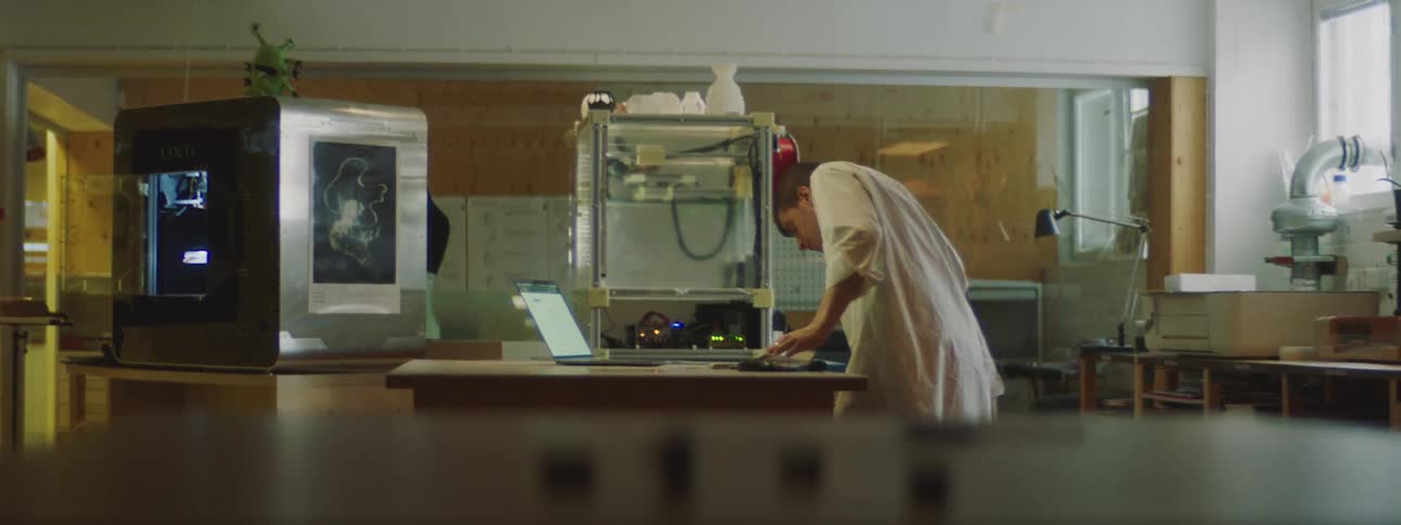A man is looking at a laptop in a room