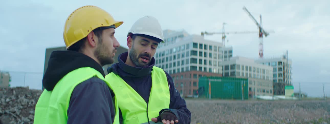 Two co workers talking at a construction site