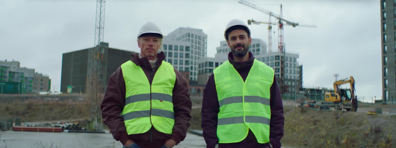 Two male construction workers posing at a construction site