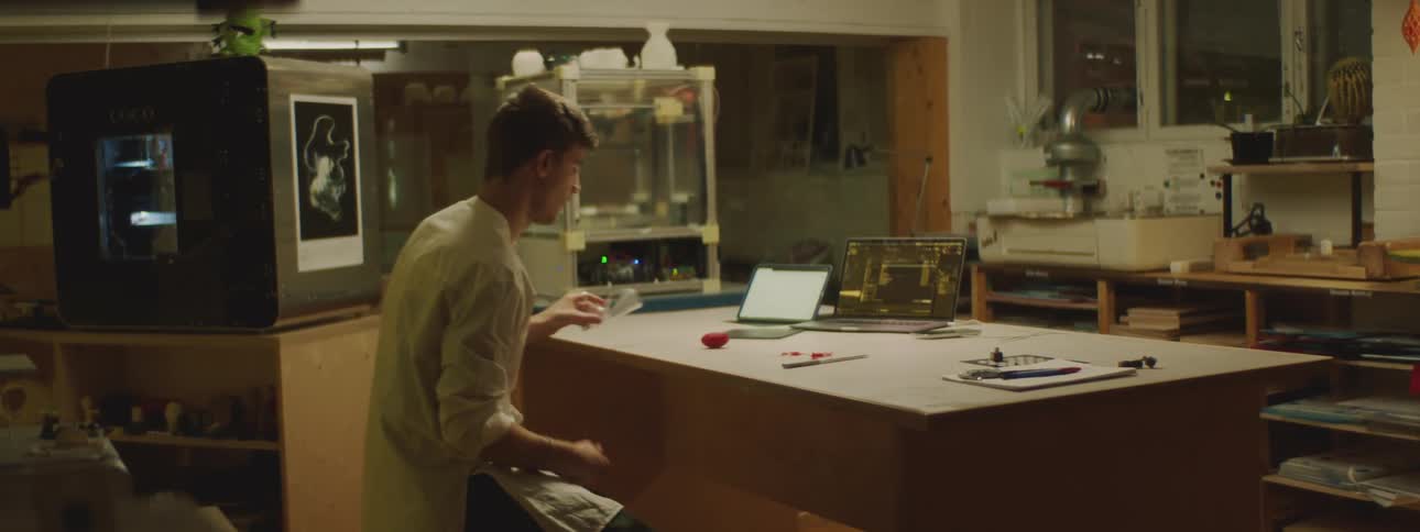 A man is sitting at a desk with a laptop on it