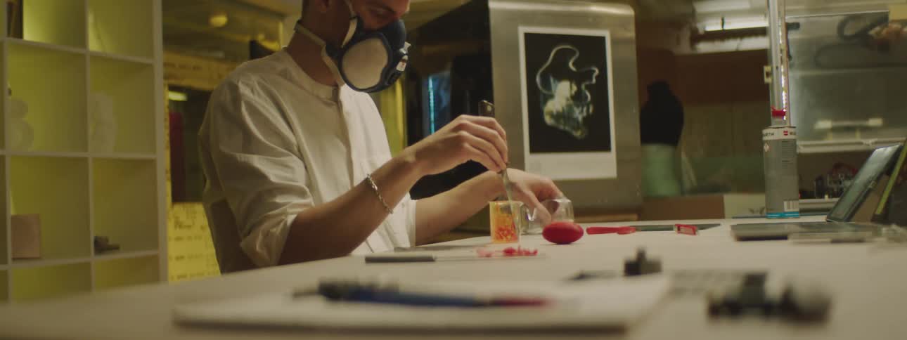 A man is working in a lab and wearing goggles