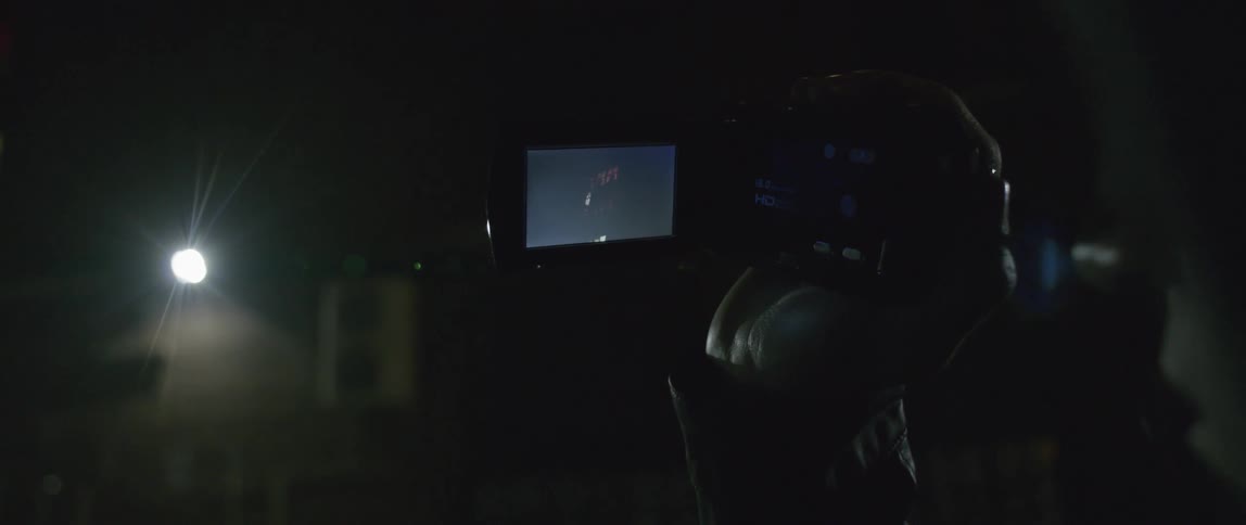 A person films something with a camcorder