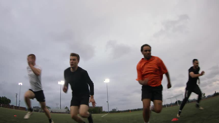 Four soccer players run in the stadium during a training exercise