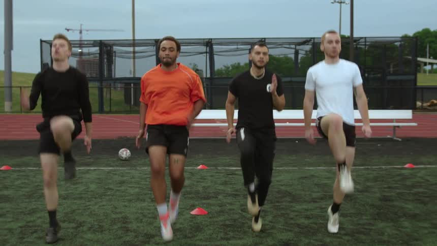 Four athletes train on sports field