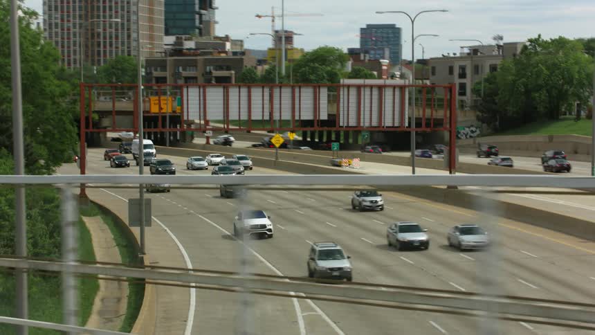 Cars travel down the highway through downtown