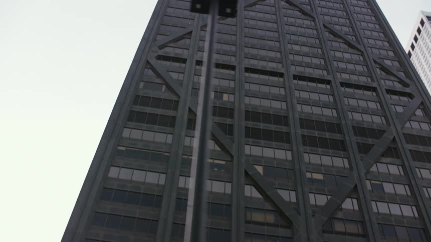 The sun shines on the John Hancock Building as the view travels up the modern architecture and black paint