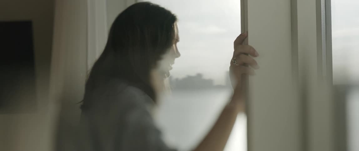 A woman is looking out a window