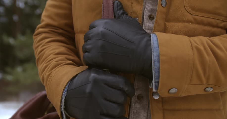 A person grasps the strap on their book bag