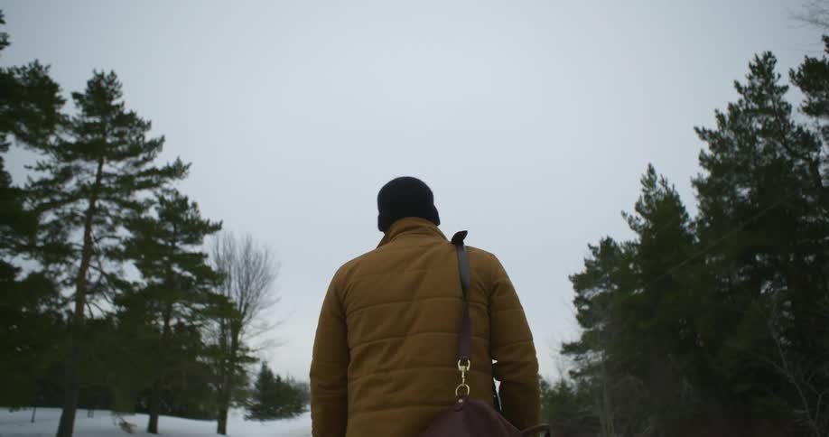 A man is hiking outside on a snow covered trail