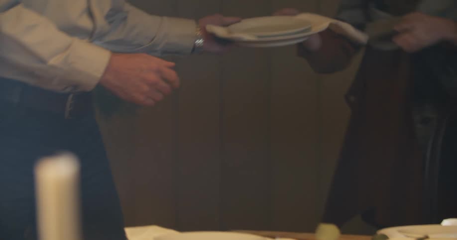 A man sets a dining room table