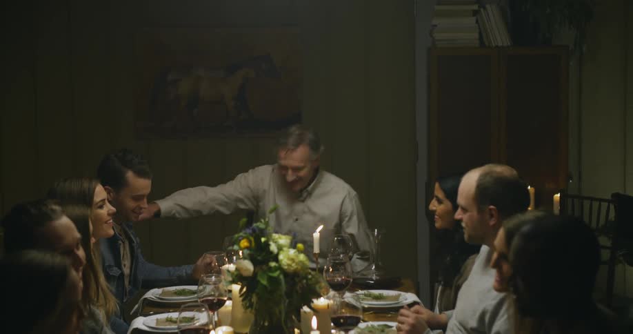 A man sits at the head of a table