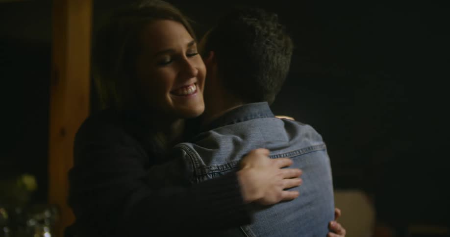 A man and woman hug and smile at each other