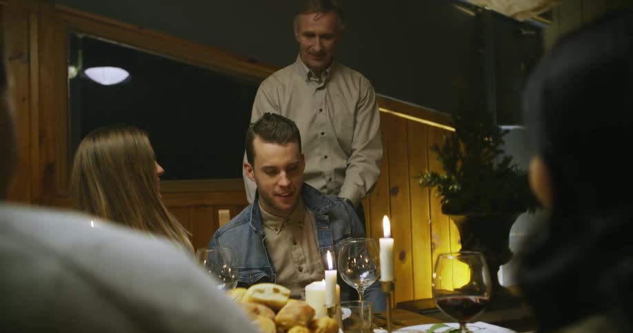 A man is walked over and seated at a table as they both smile