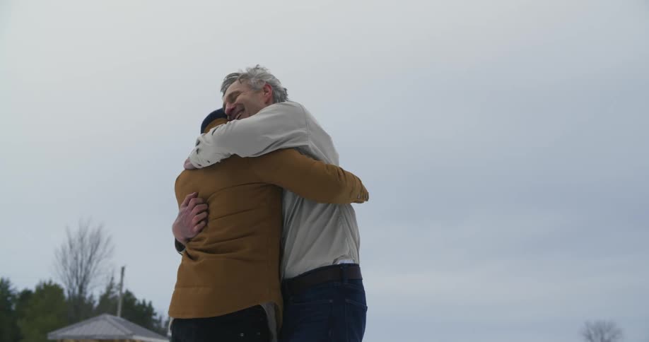 Two men running towards each other before embracing