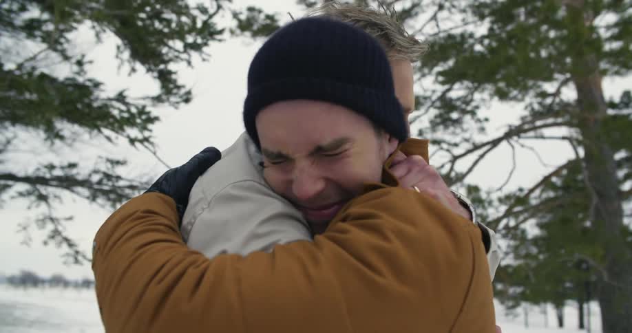 Two men embrace outside in the winter