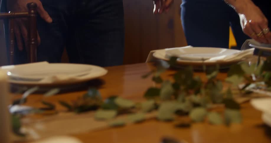 People are setting a dining room table