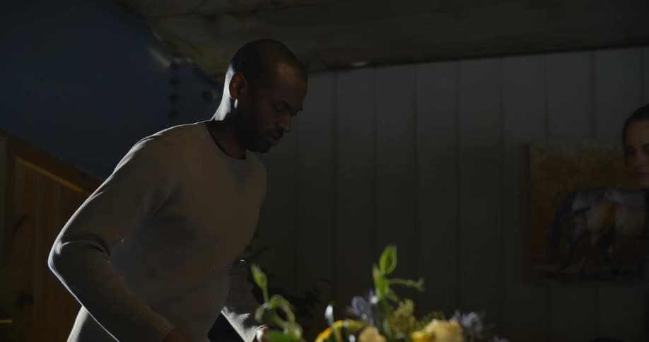 A man brings a chair to a table with many candles on it