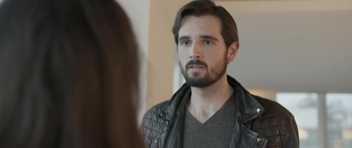 A bearded man in a jacket steps forward