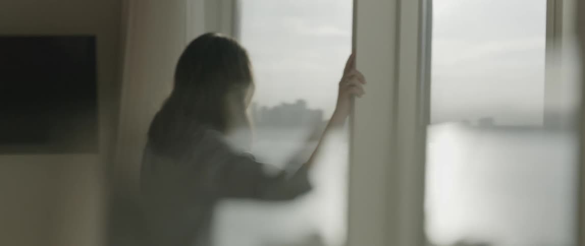 A woman looks out her window