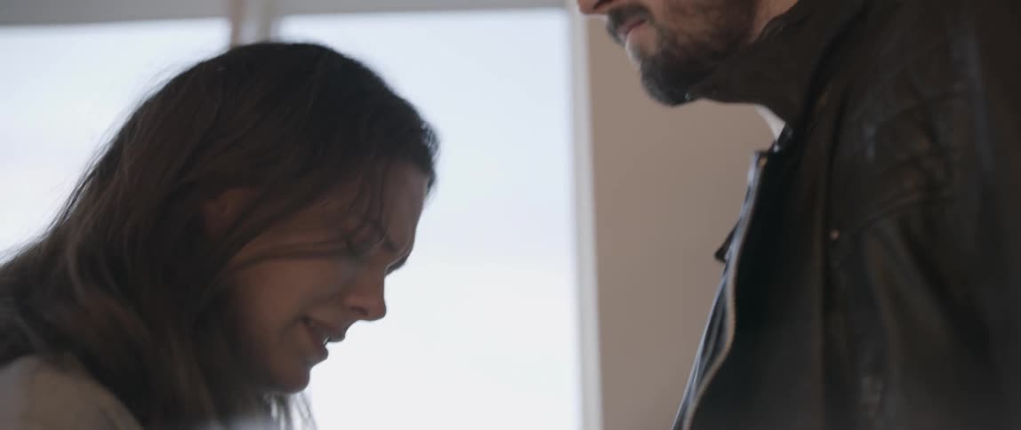 A woman is crying as a man stands next to her