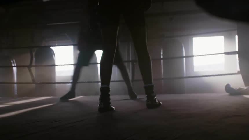 Two men spar in a boxing ring