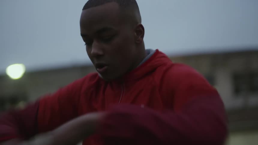 A man is outside doing boxing exercises with his arms