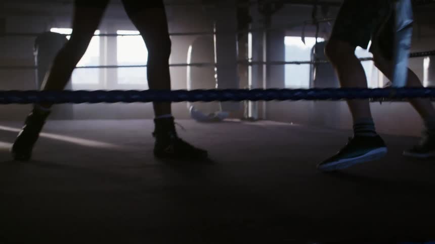 Two men are boxing in the gym