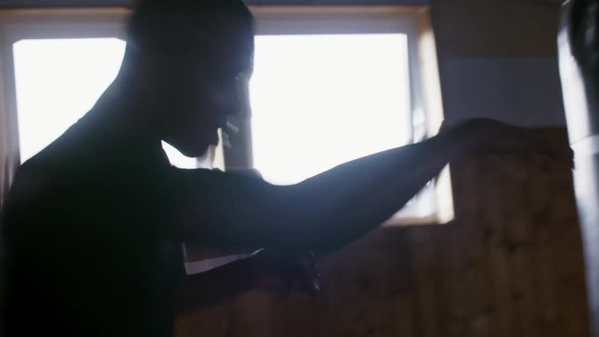 A man throws punches in the air as he boxes