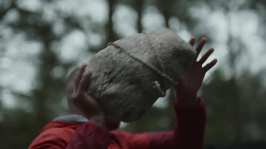 A man throws a large rock