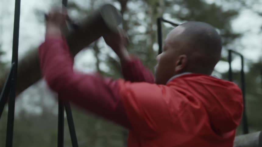 A man is using exercise equipment outdoors