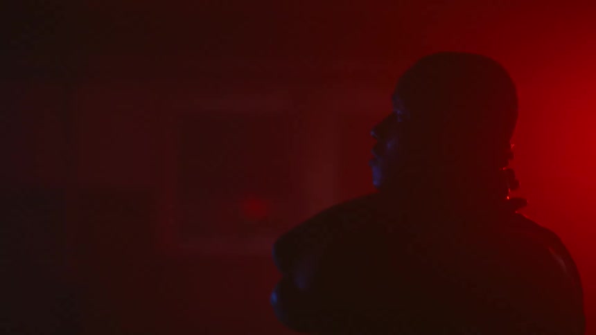 Man holds his nape in red light