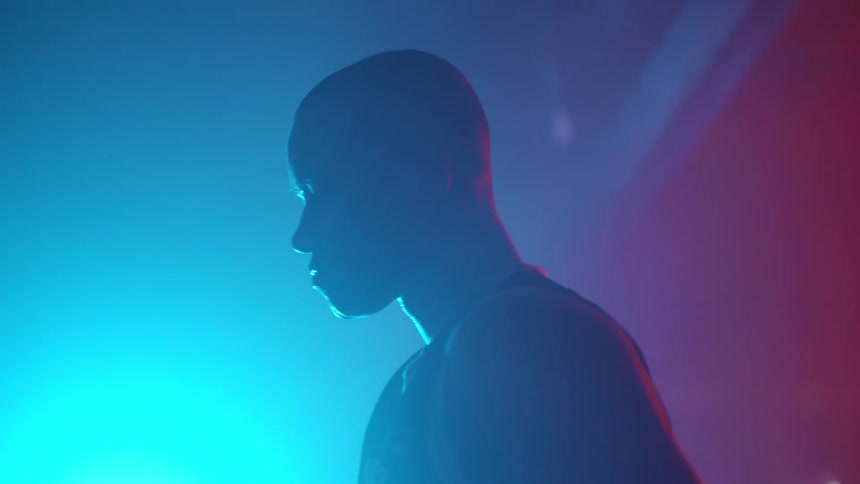 Colorful lights fill a room as a boxer throws punches in the air