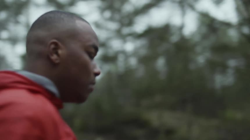 A man is walking past the trees