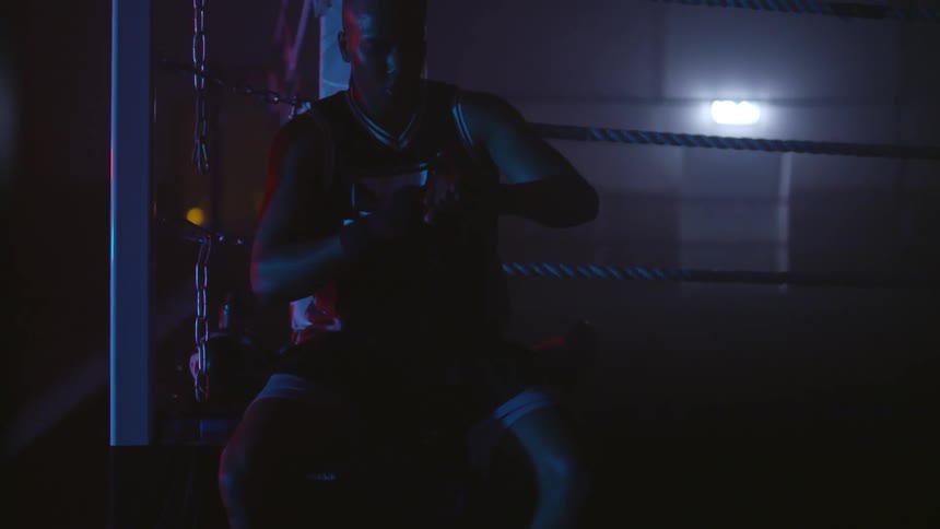 A man is taping his hands in the gym