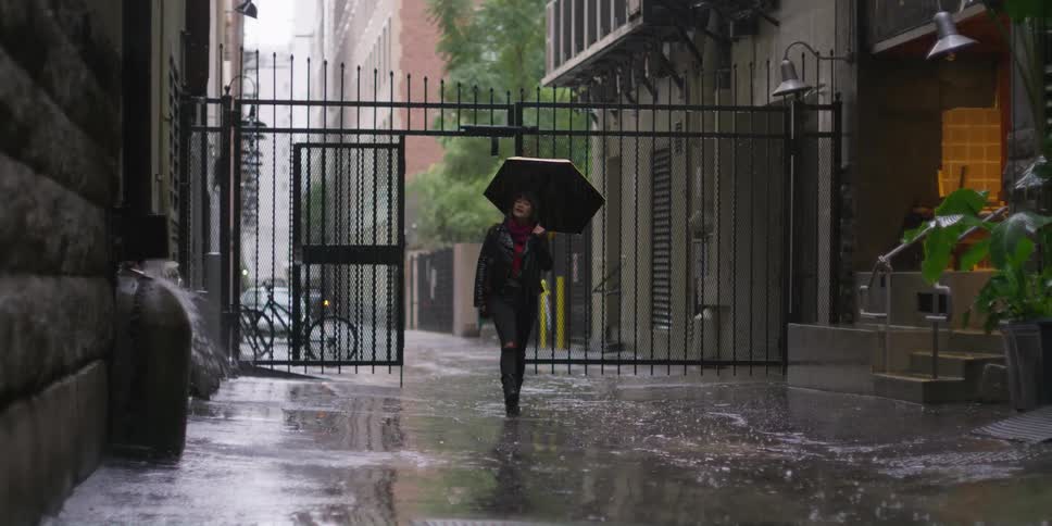 A woman walks in the pouring rain