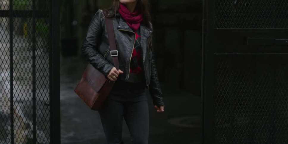 A woman walks out the gate of the alley