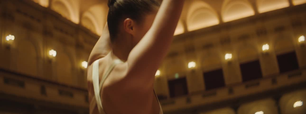 Two female ballerinas dancing in a concert hall on stage