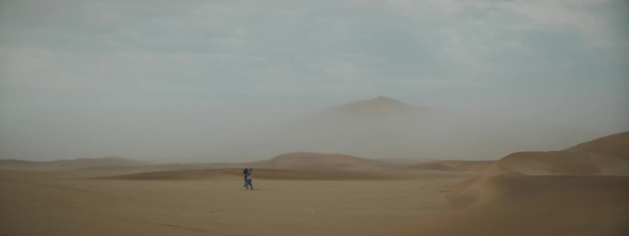 Two people are running in the desert