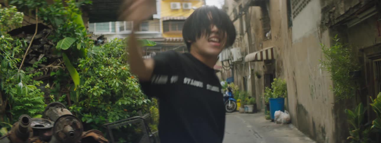 A teenage boy dancing in a neighborhood street