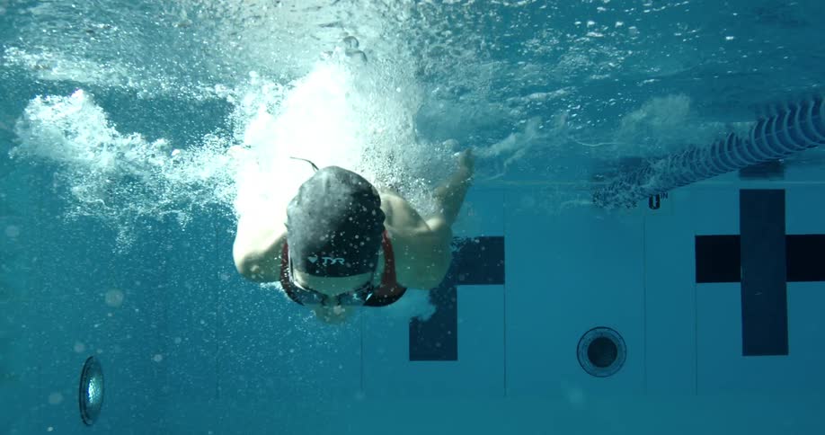 A woman dives into a swimming pool