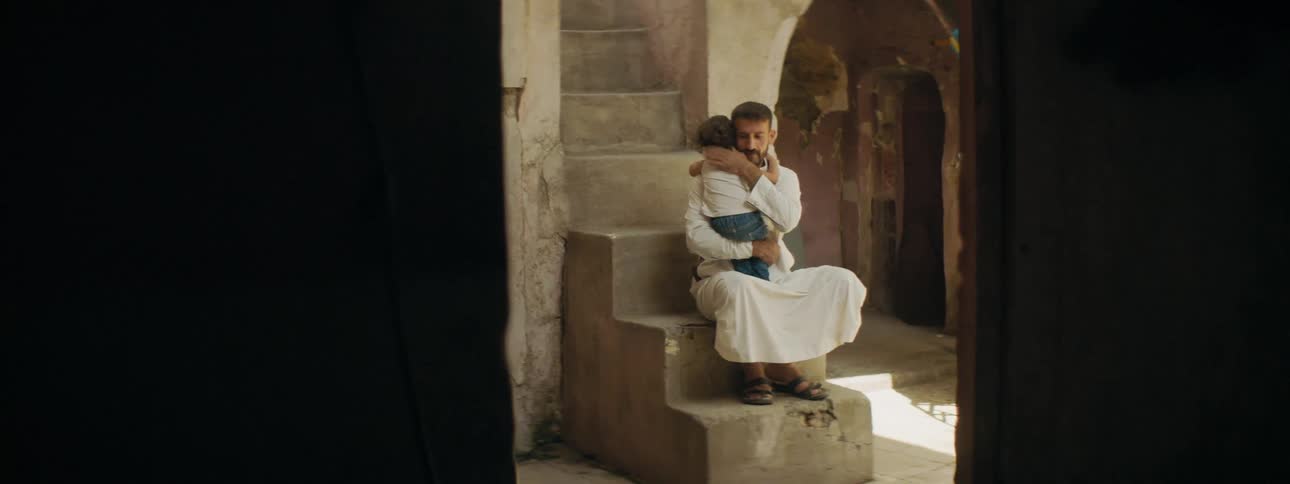 A father hugs and pats his childs back