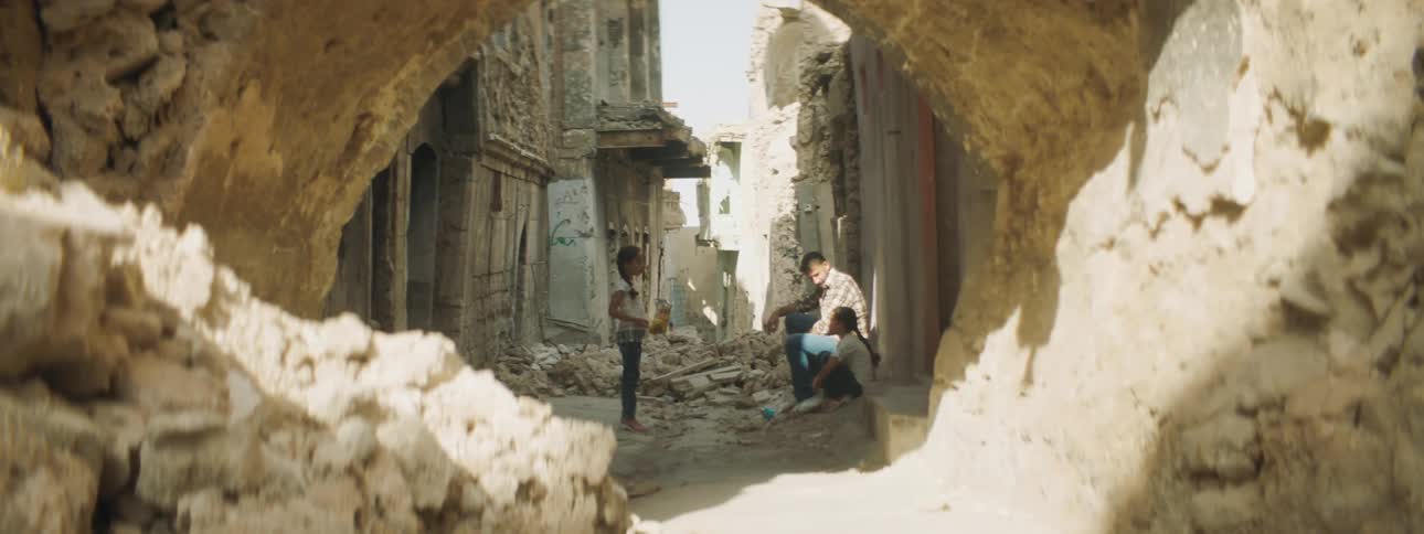 Family sitting in rubble talking