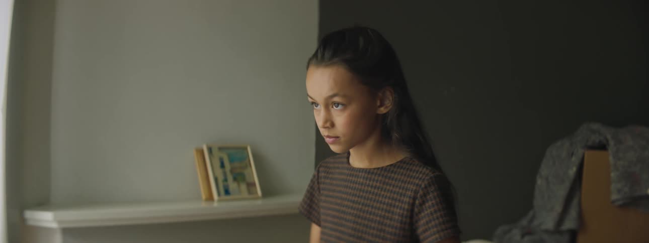 A young girl at home looks at a photo