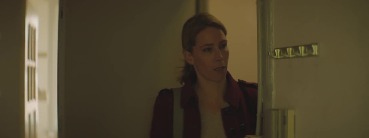A girl running through a door as a woman stands in the doorway and hangs up keys on a key hook