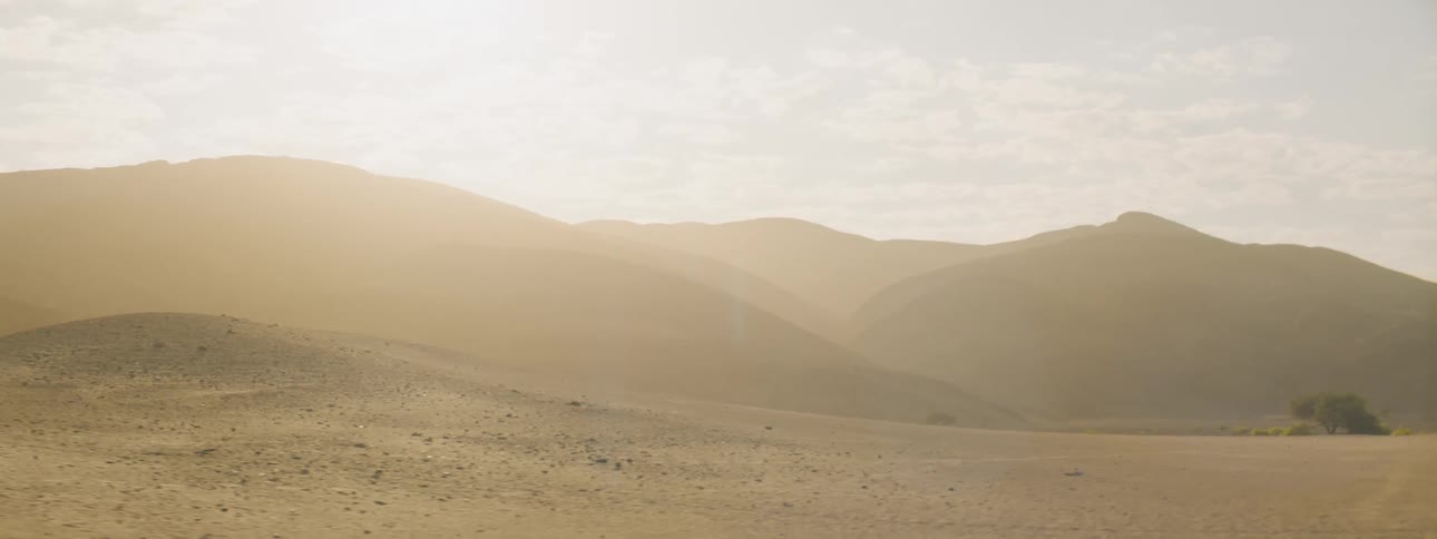 Sunlight shining over sand dunes in a desert