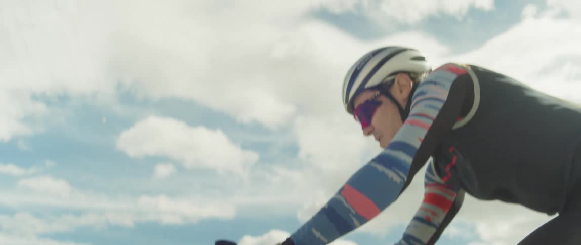 Man rides a bicycle on a desert close to wind turbines