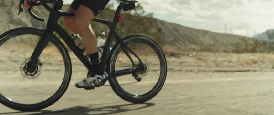 A man rides his bicycle past a canyon