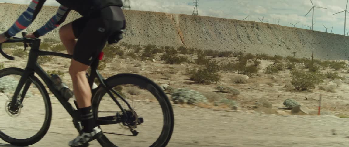 A man riding a bicycle on a desert gravel road